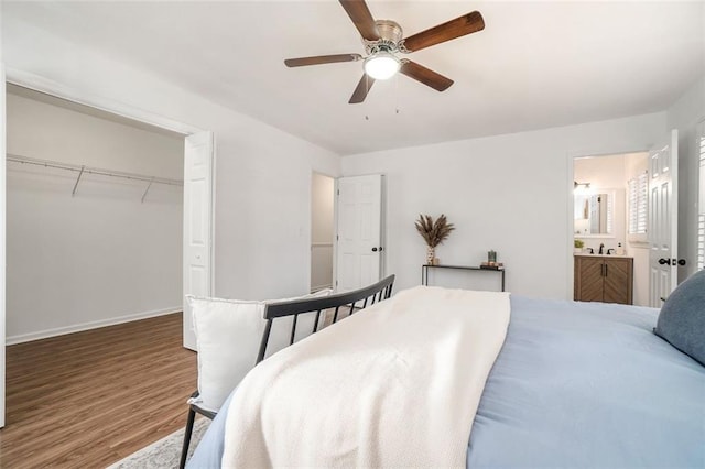 bedroom with a closet, ceiling fan, wood-type flooring, and ensuite bath