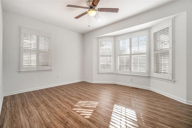 spare room featuring dark hardwood / wood-style floors and ceiling fan