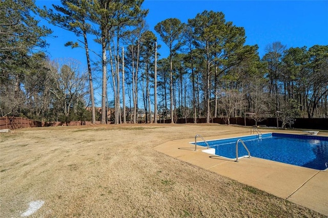 view of swimming pool featuring a diving board and a lawn