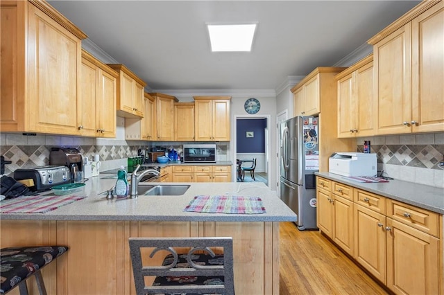 38 Olde Wick Trl, Hoschton, GA 30548 - kitchen featuring stainless steel appliances, light brown cabinets, a peninsula, crown molding, and light wood-style flooring