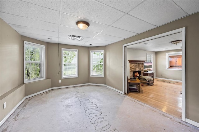 38 Olde Wick Trl, Hoschton, GA 30548 - unfurnished room featuring a fireplace, a drop ceiling, healthy amount of natural light, and unfinished concrete flooring