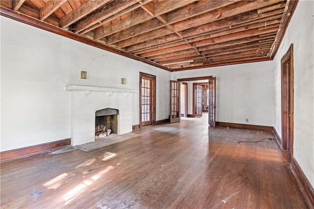 1225 Clifton Rd, Atlanta, GA 30307 - unfurnished living room with beamed ceiling, dark hardwood / wood-style flooring, a tile fireplace, and french doors