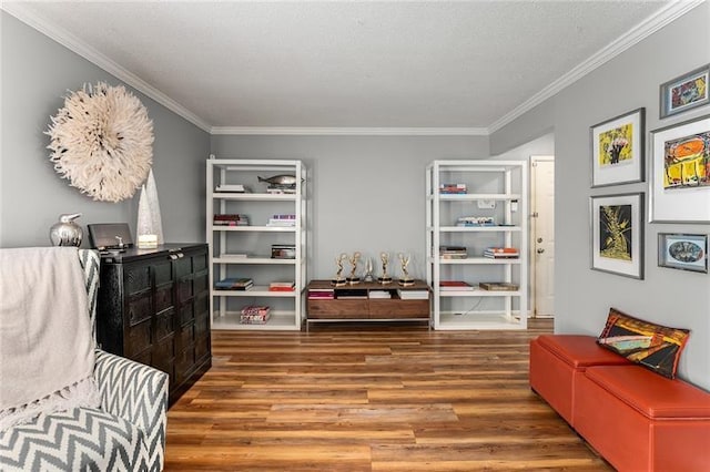 sitting room with hardwood / wood-style floors and ornamental molding