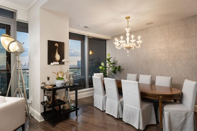 dining space with dark wood-style flooring, wallpapered walls, a notable chandelier, and baseboards