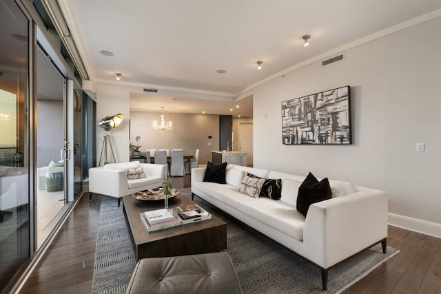 living area with crown molding, a notable chandelier, visible vents, and dark wood finished floors