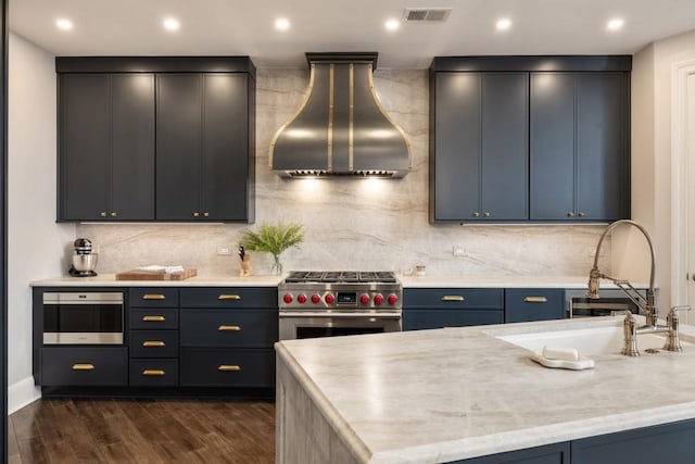 kitchen featuring appliances with stainless steel finishes, wall chimney exhaust hood, backsplash, visible vents, and dark wood-style floors