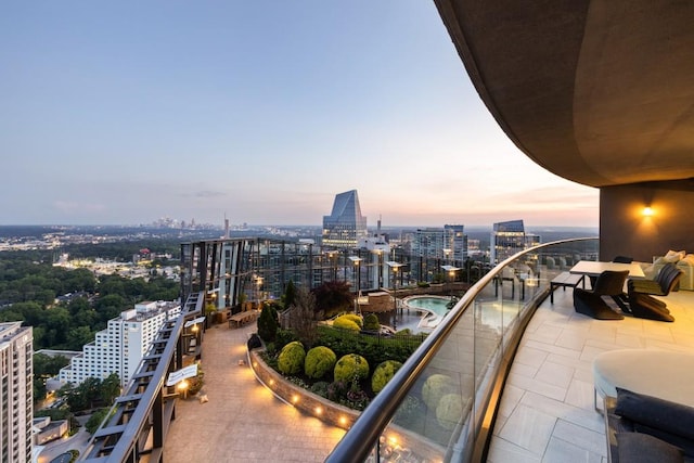 balcony at dusk featuring a view of city