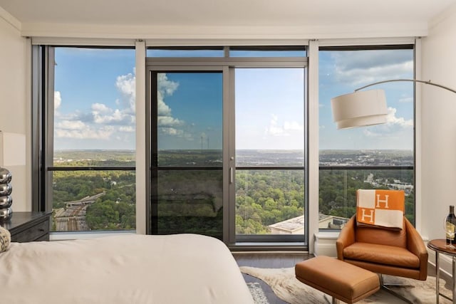 bedroom with expansive windows and wood finished floors