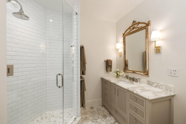 bathroom featuring vanity, baseboards, a shower stall, and tile patterned flooring
