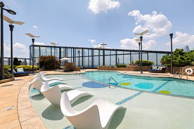 community pool featuring a patio and fence