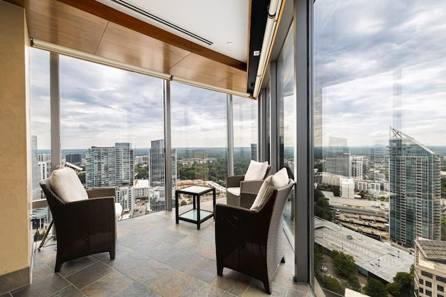 sunroom featuring a wall of windows, a view of city, and stone finish flooring