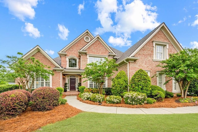 view of front of house featuring brick siding and a front yard