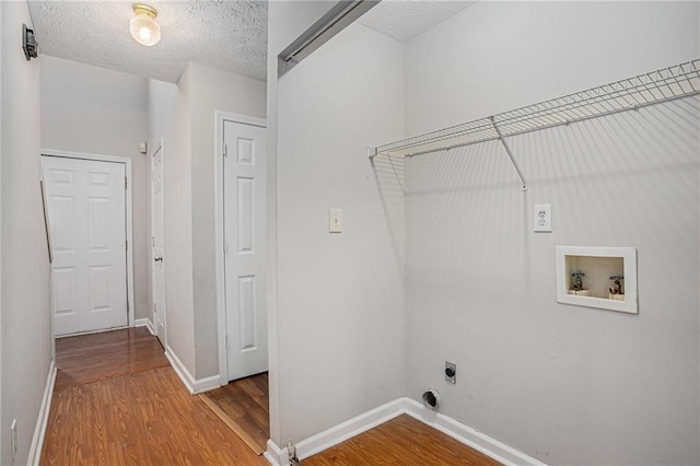 laundry room featuring hookup for a washing machine, wood-type flooring, a textured ceiling, and hookup for an electric dryer