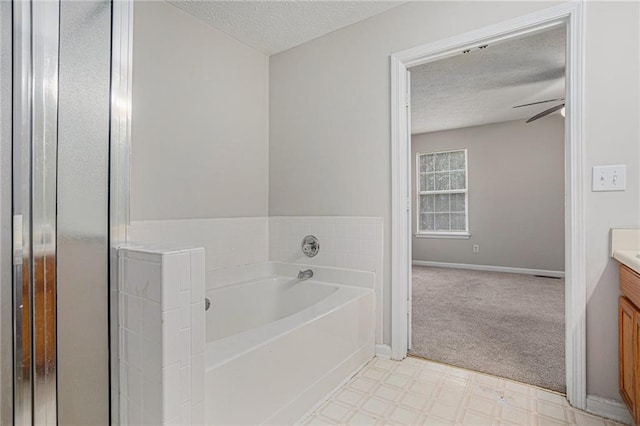 bathroom with vanity, ceiling fan, a textured ceiling, and a washtub