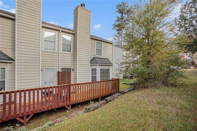 rear view of house with a deck and a lawn