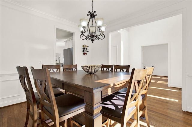 dining room featuring a notable chandelier, crown molding, and dark hardwood / wood-style flooring