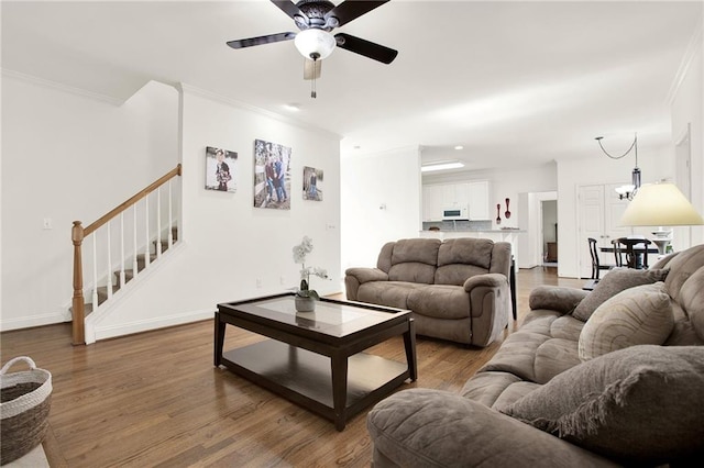 living room with ceiling fan, wood-type flooring, and ornamental molding