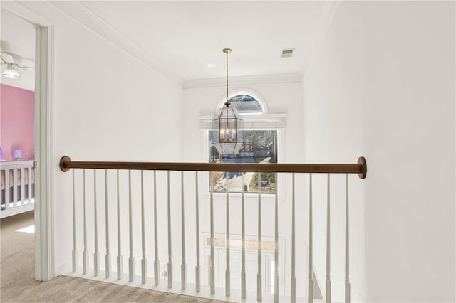 hall with carpet, an inviting chandelier, and ornamental molding