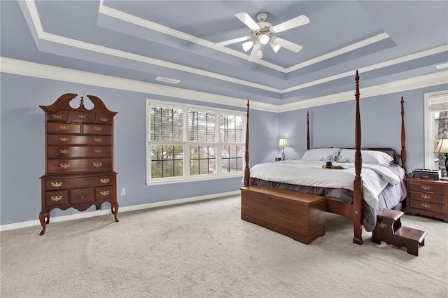 carpeted bedroom with ceiling fan, a tray ceiling, and ornamental molding