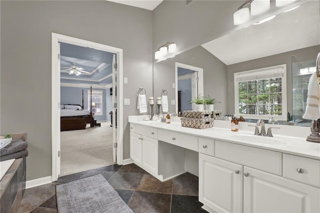bathroom featuring a tray ceiling, ceiling fan, vanity, and plenty of natural light