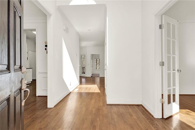 foyer with ornamental molding and hardwood / wood-style flooring