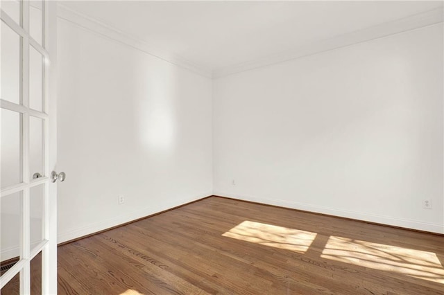 empty room with wood-type flooring and ornamental molding
