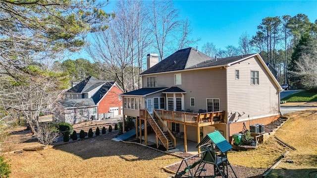 back of house with central air condition unit, a sunroom, a wooden deck, and a yard
