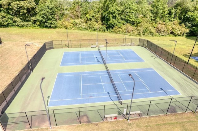 view of tennis court featuring a lawn