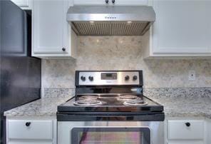 kitchen with under cabinet range hood, light stone counters, tasteful backsplash, white cabinetry, and stainless steel electric range oven