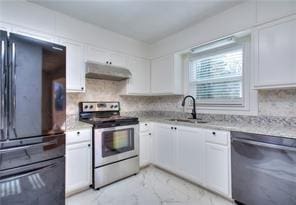 kitchen with tasteful backsplash, under cabinet range hood, white cabinets, marble finish floor, and stainless steel appliances