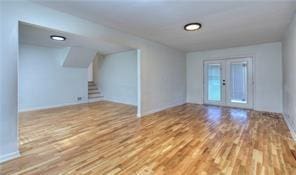 interior space featuring stairway, wood finished floors, and french doors