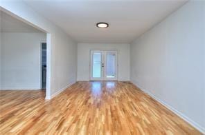 spare room with french doors and wood finished floors