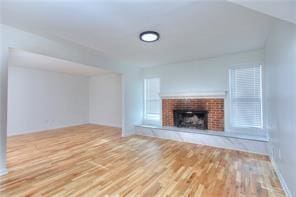 unfurnished living room featuring a fireplace and wood finished floors