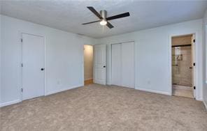 unfurnished bedroom featuring carpet flooring, connected bathroom, and ceiling fan