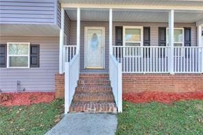 view of exterior entry featuring covered porch