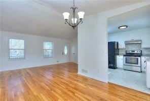 interior space with lofted ceiling, light wood-style floors, and an inviting chandelier