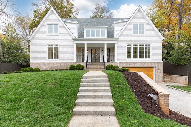 view of front facade with a front yard, a garage, and covered porch