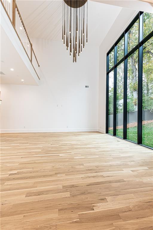 spare room with light hardwood / wood-style flooring and a high ceiling