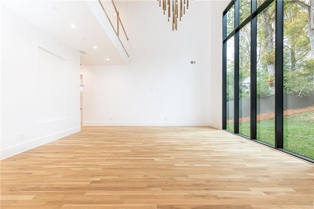 empty room with a chandelier and light hardwood / wood-style floors