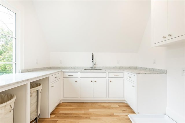 kitchen featuring white cabinetry, sink, and light wood-type flooring