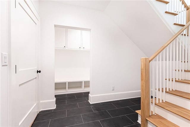 interior space with dark tile patterned flooring and lofted ceiling