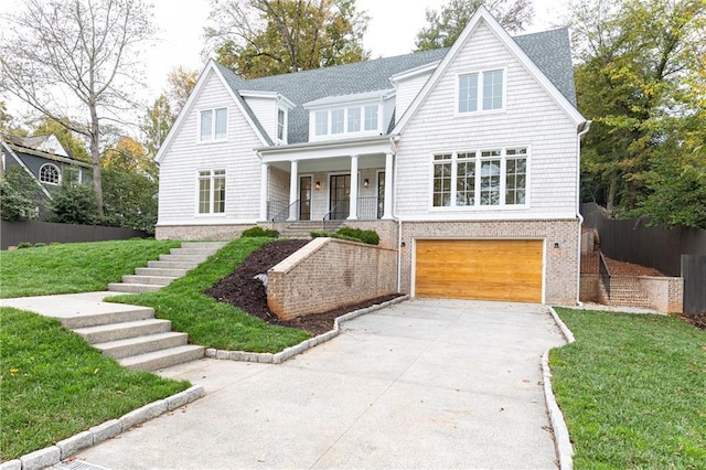 view of front facade with a front yard, a porch, and a garage