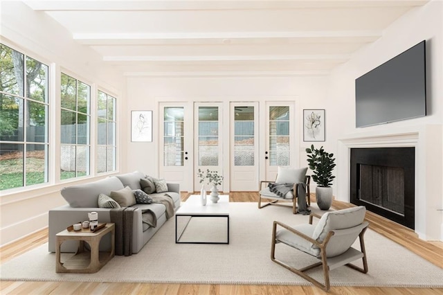 sunroom featuring beamed ceiling and a healthy amount of sunlight