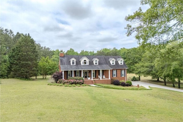 7174 Rockmart Rd, Silver Creek, GA 30173 - new england style home featuring covered porch, brick siding, concrete driveway, a front lawn, and a chimney