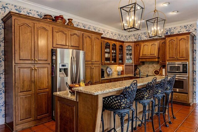 7174 Rockmart Rd, Silver Creek, GA 30173 - kitchen with brown cabinetry, stainless steel appliances, an island with sink, and light stone countertops