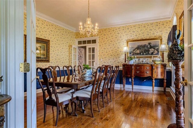 7174 Rockmart Rd, Silver Creek, GA 30173 - dining room featuring wallpapered walls, a chandelier, wood finished floors, and ornamental molding