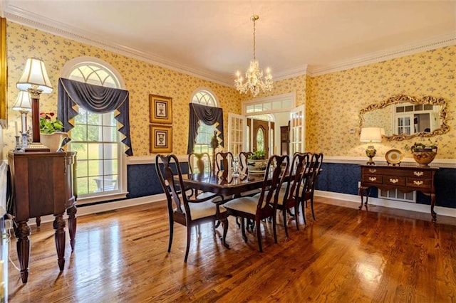 7174 Rockmart Rd, Silver Creek, GA 30173 - dining area with crown molding, an inviting chandelier, wallpapered walls, and wood finished floors