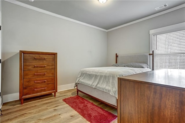 bedroom with light hardwood / wood-style floors and crown molding