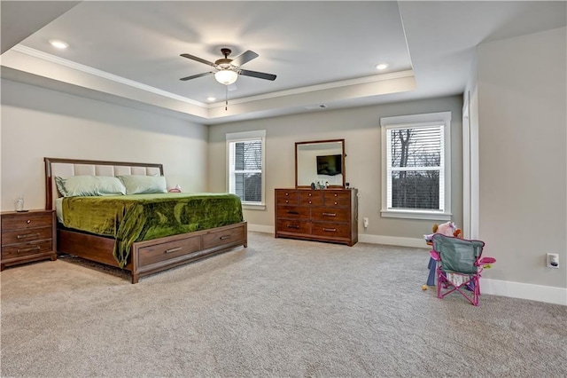 carpeted bedroom featuring ornamental molding, a raised ceiling, ceiling fan, and multiple windows