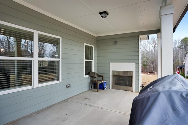 view of patio with an outdoor fireplace and a grill